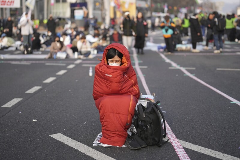 4日在韓國憲法法院附近聚集許多徹夜等待要求彈劾總統尹錫烈的民眾。(美聯社)