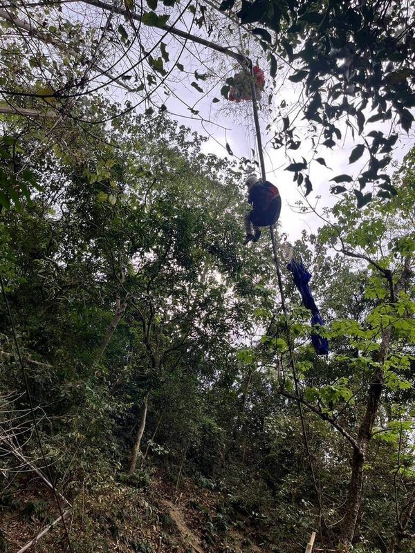屏東縣一名飛行傘玩家4日下午操作時發生意外,連人帶傘掛在10公尺高的樹上,消防局獲報馳援,所幸玩家順利脫困後並無明顯傷勢。(屏東消防局提供)中央社記者李卉婷傳真 114年4月4日
