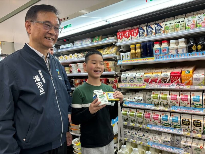 台北市「鮮奶週報」7日起試營運,教育局長湯志民(左)首日下午陪同國小學子前往超商兌領乳品,他指出,「鮮奶週報」上路後,兌領情形大致順利。中央社記者陳昱婷攝 114年4月7日