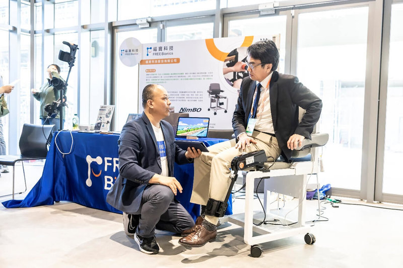 數發部數產署於8日舉辦「2025年產業AI化交流及媒合會DEMO DAY-健康照護」活動,邀醫療照護機構與AI業者,針對健康照護產業如何導入AI技術進行交流。圖為數發部政務次長林宜敬(右)體驗智慧輔具業者產品。(數發部提供)中央社記者蘇思云傳真 114年4月8日
