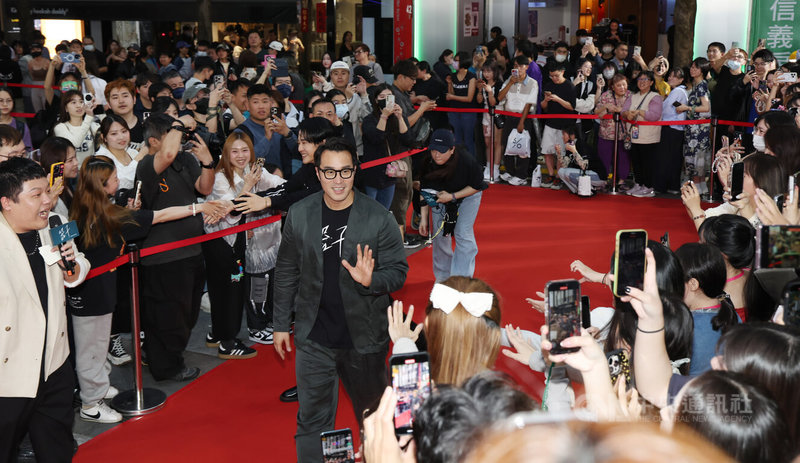 電影「器子」9日在西門町封街舉辦首映會,劇中演員張孝全(前中)等人出席活動為片宣傳,吸引大批粉絲到場爭睹偶像風采,紛紛拿出手機搶拍。中央社記者張新偉攝 114年4月9日