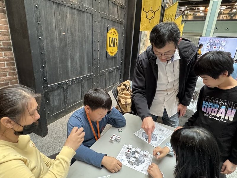 國立台灣科學教育館響應2025國際量子年,12日舉辦科普市集等活動,13日並將舉行「量子井字棋」決賽。圖為中原大學教授溫文鈺(左3)日前在科教館教民眾玩量子井字棋。(科教館提供)中央社記者陳至中傳真 114年4月12日