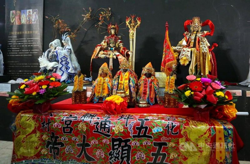 彰化縣大村鄉埤腳五通宮信眾日前帶著五顯大帝5神尊(前排),至嘉義縣表演藝術中心展覽廳觀看三昧堂「當偶們童在一起之五顯神威」精工戲偶展覽。後排右1為五顯大帝精工布袋戲偶。中央社記者蔡智明攝 114年4月14日