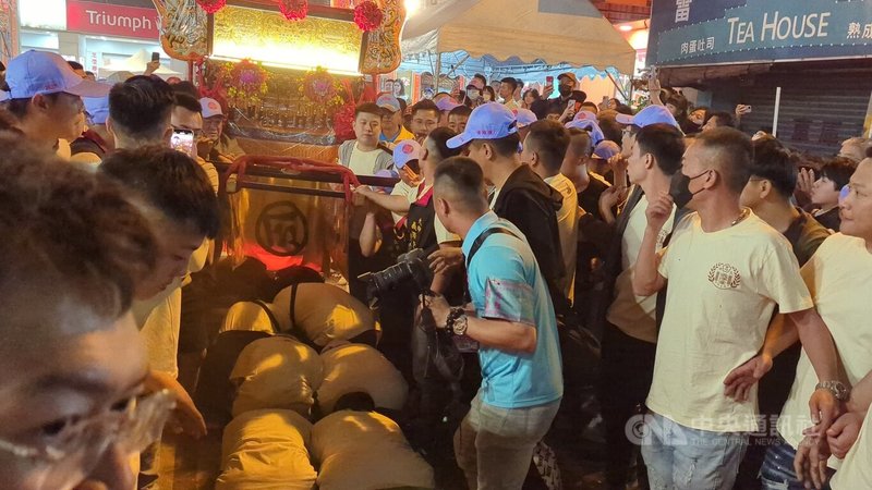 台中大甲鎮瀾宮媽祖遶境活動13日回鑾行程延遲逾2個小時,沿途許多信眾簇擁,排隊等候鑽轎底。中央社記者蘇木春攝 114年4月14日