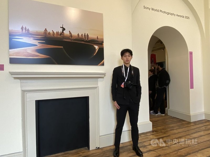 在英國倫敦薩默塞特宮攝影展中,台灣青年吳典積站在自己的作品前,他說,他想表現的是夕陽寧靜之美與年輕滑板運動者所散發的熱情與自由。中央社記者黃佩珊倫敦攝 114年4月17日