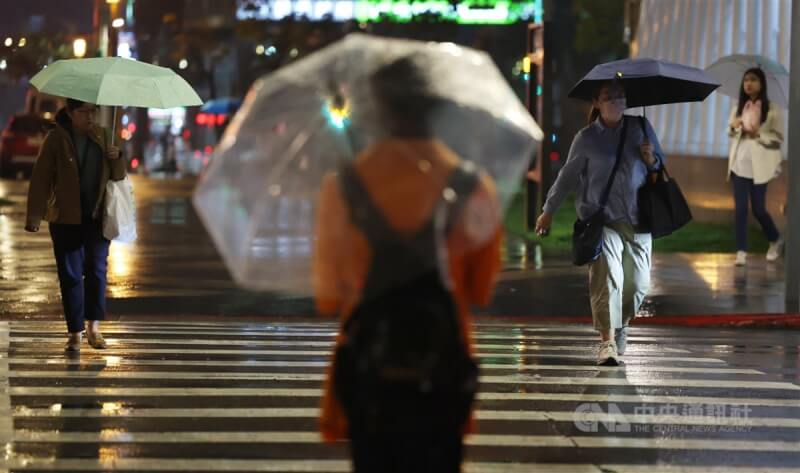 台北市松山區街頭民眾撐傘擋雨。(中央社檔案照片)