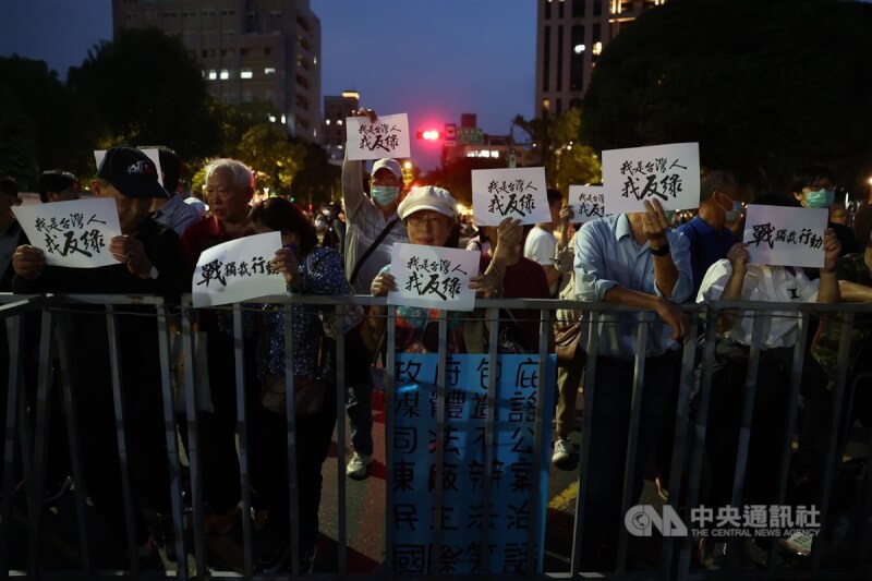 台北地檢署偵辦幽靈連署案,國民黨主席朱立倫17日號召黨公職及群眾晚間到北檢外集結,「為台灣戰獨裁」,吸引許多民眾響應,手持標語在北檢外表達立場。中央社記者王騰毅攝 114年4月17日