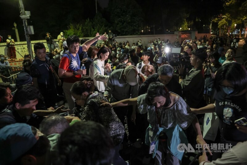 國民黨立委王鴻薇(中左白衣)與支持者一起踏過拒馬,前往北檢前聲援。中央社記者趙世勳攝 114年4月17日
