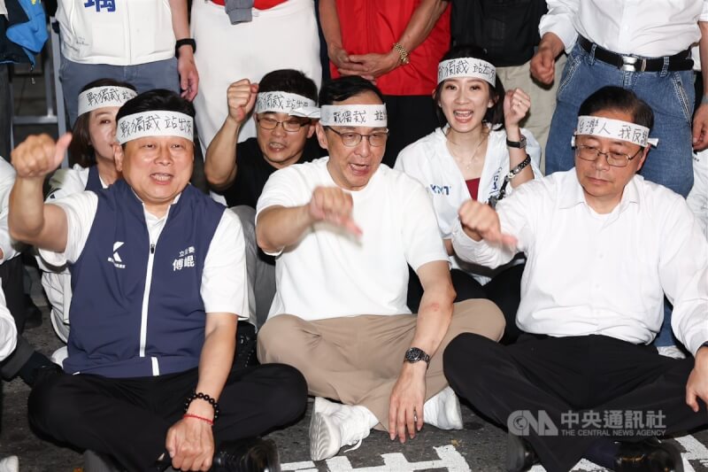 國民黨主席朱立倫(前中)與桃園市長張善政(前右)、立院黨團總召傅崐萁(前左)等人17日晚間到北檢外與支持者一同抗議司法不公,在頭上綁起布條、手比倒讚表訴求。中央社記者王騰毅攝 114年4月17日