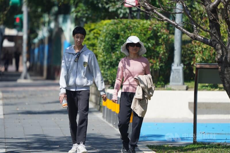 圖為台北市北投區有民眾外出時將外套拿在手上。(中央社檔案照片)