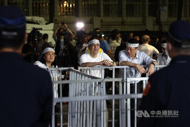 國民黨主席朱立倫(中)17日號召黨公職及群眾晚間到北檢外集結抗議,他頭綁「戰獨裁、站出來」布條,直至跨夜仍未離去,隔著柵欄與警方對峙。中央社記者王騰毅攝 114年4月18日