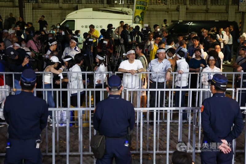 檢調17日約談涉不實連署案的國民黨北市黨部主委黃呂錦茹等人,國民黨主席朱立倫(中白衣者)號召黨公職及支持者晚間到北檢外集結抗議,至深夜仍有數百人不願離去。中央社記者王騰毅攝 114年4月18日