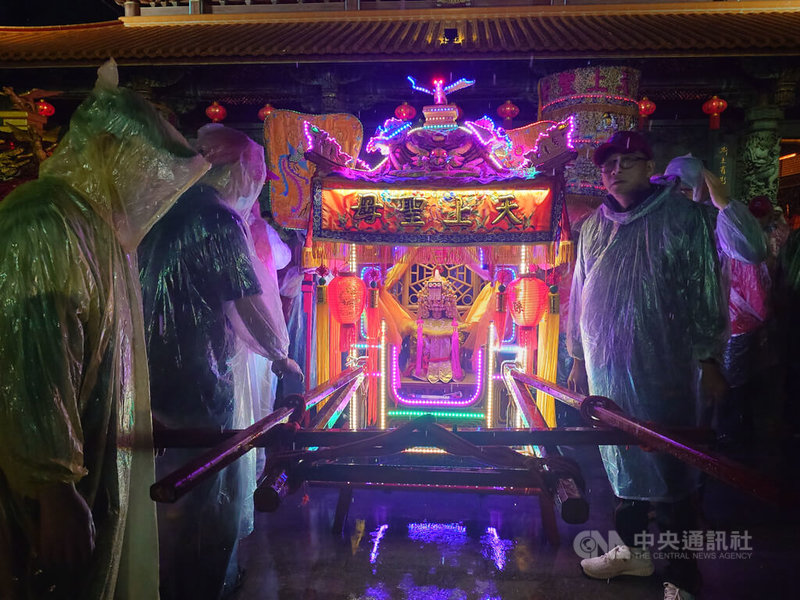 馬祖境天后宮每年都為媽祖誕辰舉辦盛大慶祝活動,19日晚間安排祈安遶境遊行,廟方人員在大雨中將媽祖神像請入轎內。中央社記者潘欣彤攝 114年4月19日