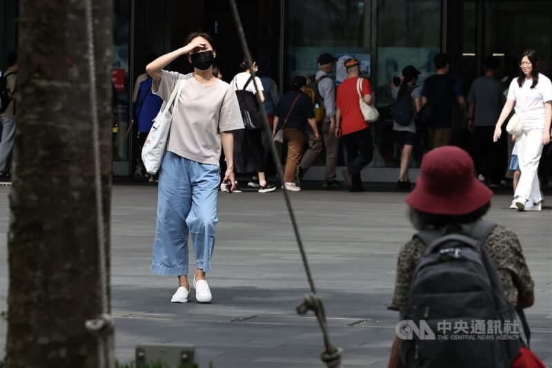 圖為台北市南港區午後街頭民眾用手遮擋陽光。（中央社檔案照片）