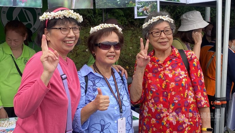2025新北市客家桐花祭「青春桐樂會」19日在土城區熱鬧登場,吸引許多民眾上山參與,開心戴著桐花花環合影。中央社記者黃旭昇新北市攝 114年4月19日