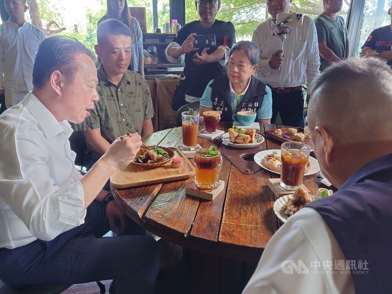 嘉義縣長翁章梁(前左1)22日前往民雄鄉魚罐頭咖啡館,在老闆翁哲偉(前左2)陪同下,品嚐店裡招牌肉粽搭配特調咖啡,直說有創意。中央社記者蔡智明攝 114年4月22日