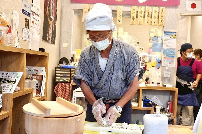 高雄市鼓山區一家日式飯糰店因租賃糾紛引發各界關注,許多人到店消費表達支持,因短時間內湧入大量訂購需求,店家22日持續忙著製作飯糰。中央社記者董俊志攝 114年4月22日