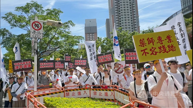 不滿衛福部中藥販售新令,上百名藥師22日赴衛福部大門口快閃抗議,要求撤回318違法解釋令。中央社記者沈佩瑤攝 114年4月22日