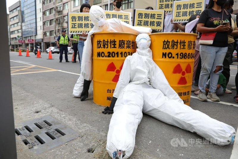 南台灣廢核行動聯盟等20個公民團體及第三勢力政黨23日到國民黨高雄市黨部前,以象徵核廢料桶與輻射防護裝備等物品,上演模擬核三廠發生核子事故的行動劇,呼籲在野黨以專業與審慎態度修法,正視核災風險。中央社記者張已亷攝 114年4月23日