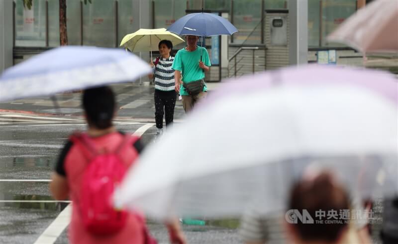 圖為台北市信義區下雨,民眾外出撐傘。(中央社檔案照片)