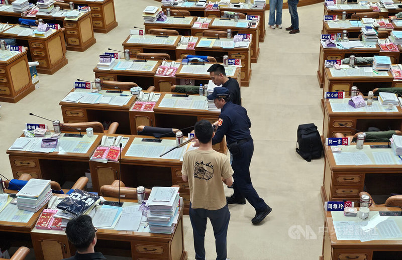 無黨團結聯盟新北市議員馬見(Lahuy.Ipin)(後)29日持獵槍進議場質詢,引駐衛警上前關切並協助保管。中央社記者王鴻國攝 114年4月29日