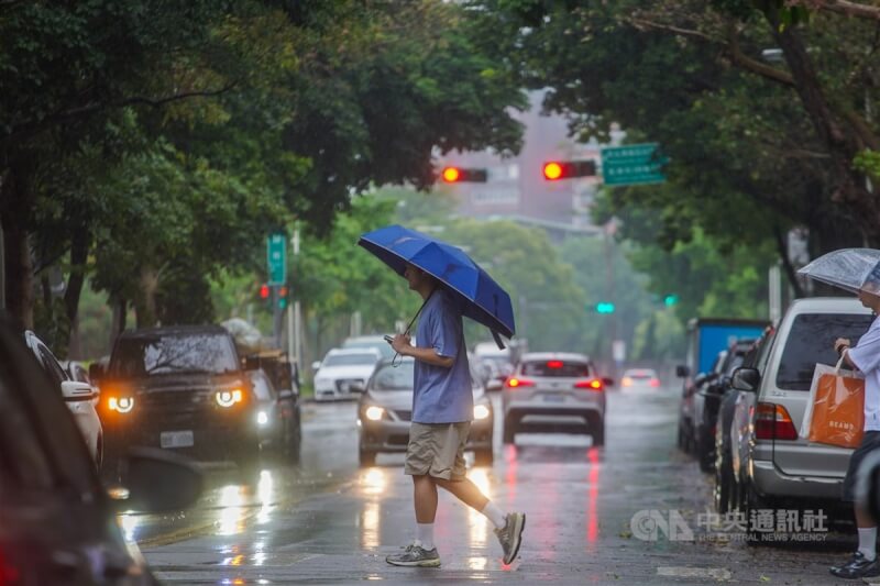 圖為台北市街頭民眾撐傘擋雨。（中央社檔案照片）