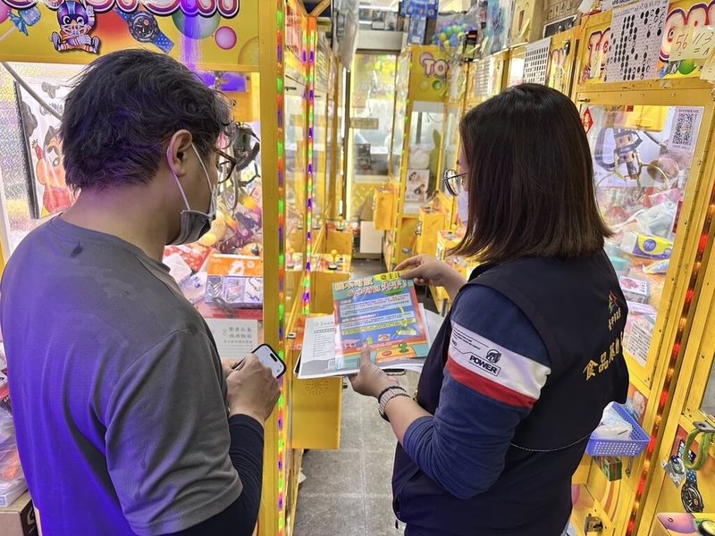 台中市食品藥物安全處盤點校園周邊及大型業者設置的販賣機,截至3月底,共查核242台機台,查獲4件涉及化粧品違規案件。圖為食安處人員輔導自助選物販賣機業者落實機台標示事項。(民眾提供)中央社記者趙麗妍傳真 114年4月30日