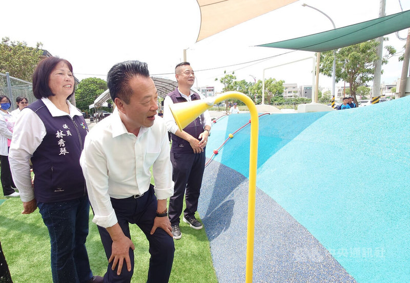 中央補助興建嘉義縣新港鄉嘉民行政園區兒童遊戲場30日啟用,縣長翁章梁(前中)現場試傳聲筒傳話功能。中央社記者蔡智明攝 114年4月30日
