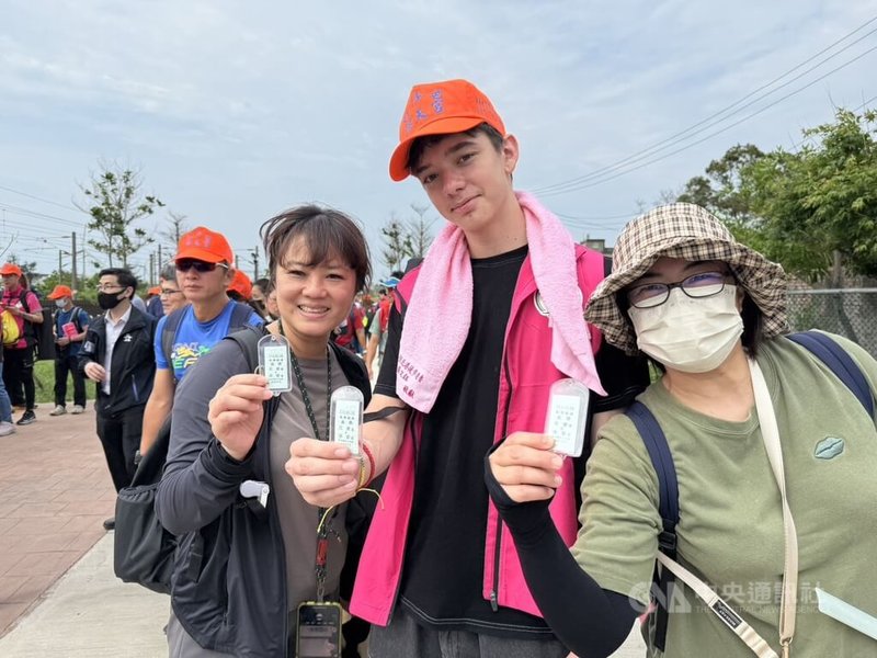 白沙屯媽祖進香活動1日深夜將啟程,交通部與台鐵特別製作限量版「永保安康車票」疏運平安守。來台學語文並首次體驗進香活動的法國交換生(右2)也與友人一起排隊領取。中央社記者管瑞平攝 114年5月1日
