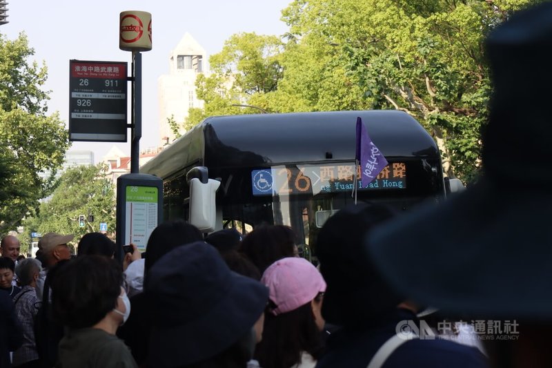 1日到5日的長假期間,上海口岸出入境客流總量預計年增3成。中國去年以來單方面開放免入境簽證,盼以此促進消費,韓國客明顯增多。圖中有導遊拿著韓語旗幟在上海市區帶團員走逛。中央社記者張淑伶上海攝 114年5月1日