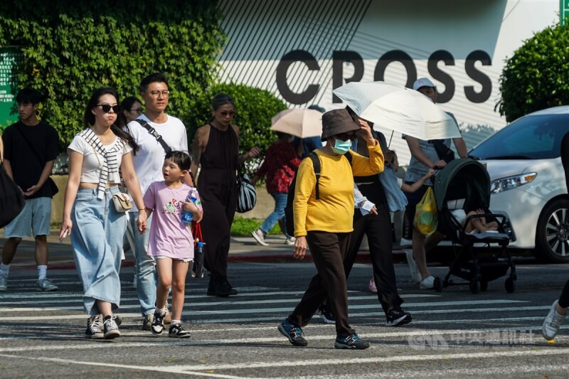 圖為台北市中山區街頭,民眾戴墨鏡、撐傘遮陽。(中央社檔案照片)