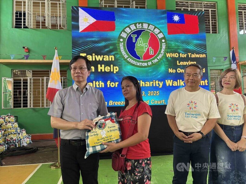 菲律賓台灣同鄉會3日在大馬尼拉地區卡羅肯市舉辦Taiwan Can Help公益健走,會長白適榮(左)在健走後分發白米及生活物資給1000名當地居民。中央社記者林行健卡羅肯市攝 114年5月3日