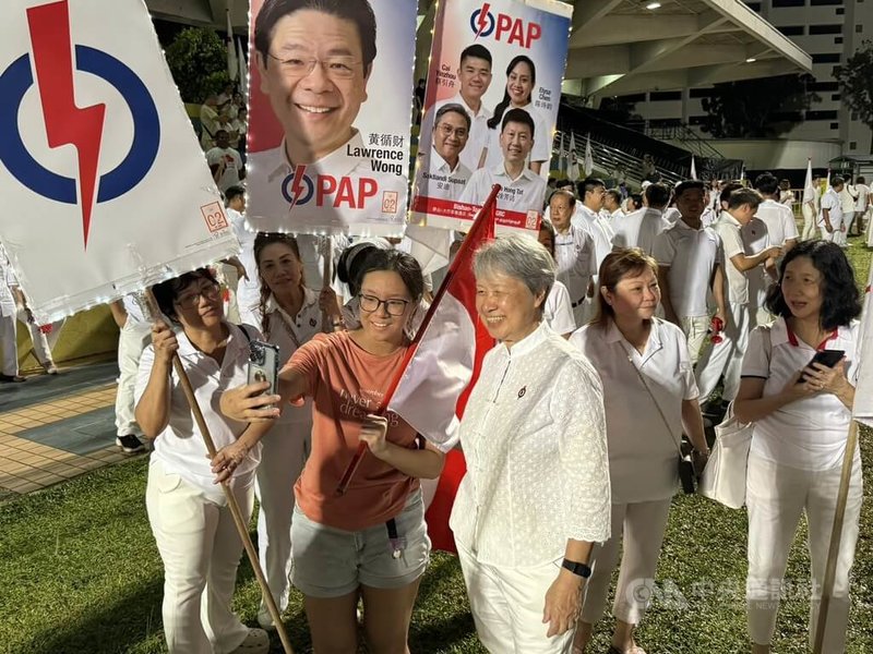 新加坡大選登場,新加坡前總理李顯龍夫人何晶(右3)抵達人民行動黨支持者集結的楊厝港體育場,與支持者合影。中央社記者吳昇鴻新加坡攝 114年5月4日