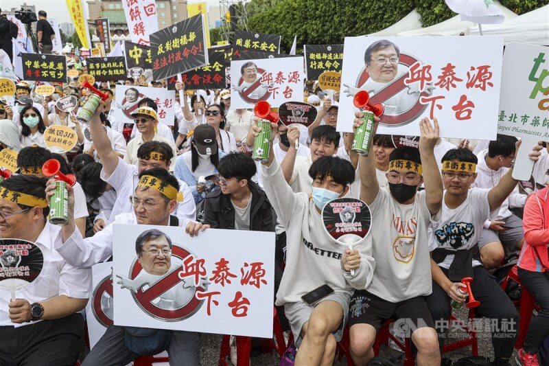 不滿衛福部中藥販售新令,中華民國藥師公會全國聯合會4日在凱達格蘭大道舉行集會抗議,參與者高舉畫有衛福部長邱泰源、中醫藥研究所長蘇奕彰的手板,要求下台。中央社記者鄭清元攝 114年5月4日