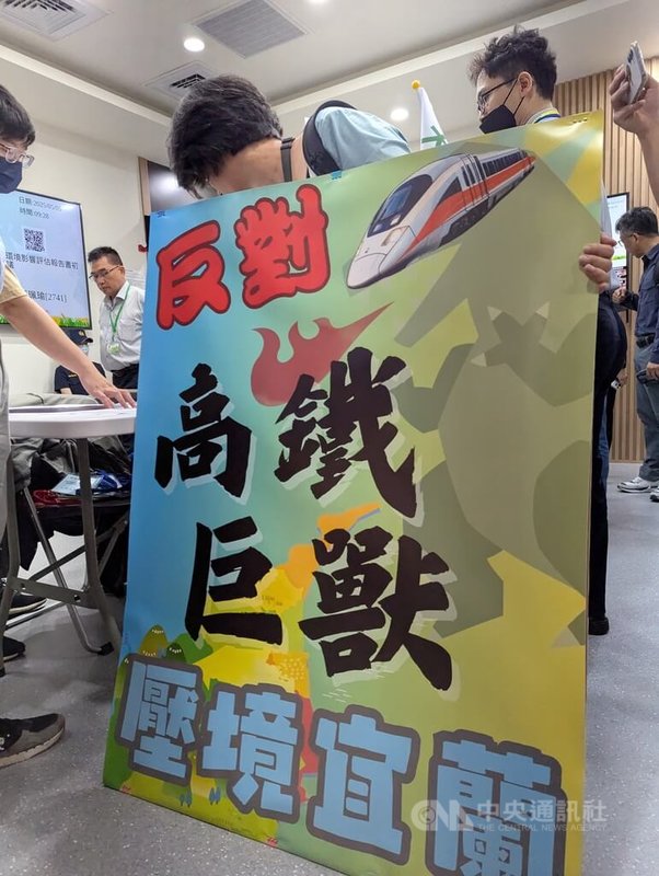 環境部5日上午9時30分舉辦「高鐵延伸宜蘭計畫環境影響評估報告書初稿」專案小組初審會議。反對方舉「高鐵巨獸」看板,辦理登記進場。中央社記者張雄風攝 114年5月5日