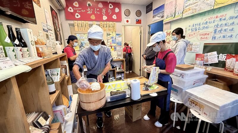 高雄市鼓山區一家日式飯糰店因租賃糾紛引發各界關注,圖為業者樋口先生(前左)製作飯糰。(中央社檔案照片)