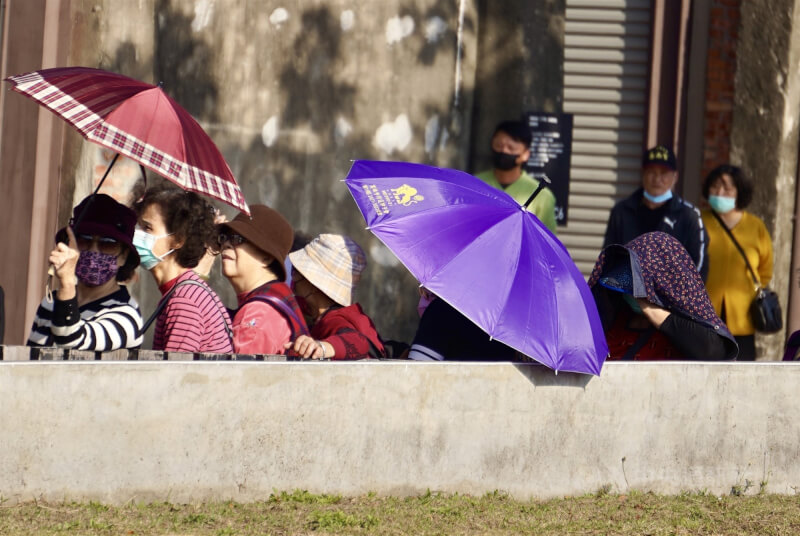 圖為高雄地區午後外出民眾撐傘遮陽。(中央社檔案照片)