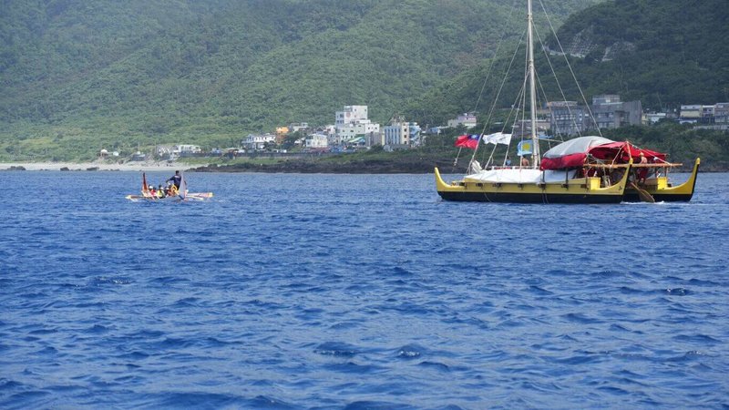 帛琉傳統帆船Alingano Maisu(右)以無動力方式航行約20天,於7日傍晚順利航抵台東蘭嶼;當帆船抵達蘭嶼海域時,達悟族人也乘拼板舟(左)出海相迎。(台東縣政府提供)中央社記者盧太城台東傳真 114年5月8日