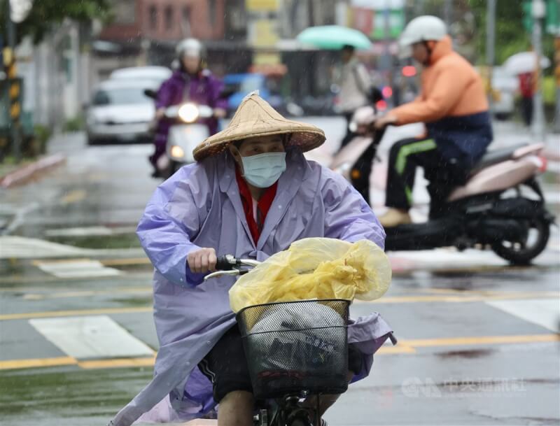 母親節將來臨,10日、11日各地降雨顯著。圖為台北市萬華區民眾穿雨衣擋雨。(中央社檔案照片)