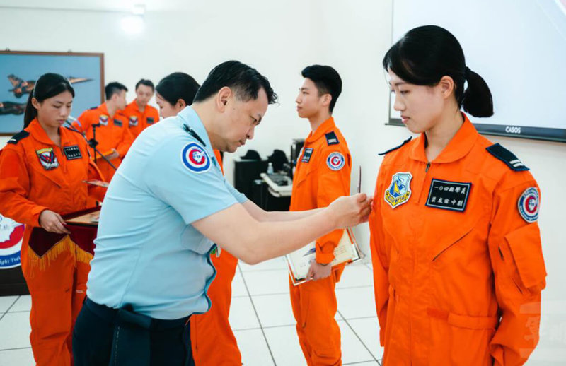 空軍飛行訓練指揮部9日舉行112-乙班單飛臂章暨證書頒授典禮,指揮官吳少將(前左)為學員(右)頒授單飛臂章,順利達成「全員通過」單飛測驗的重要里程碑。(軍聞社提供)中央社記者吳書緯傳真 114年5月10日