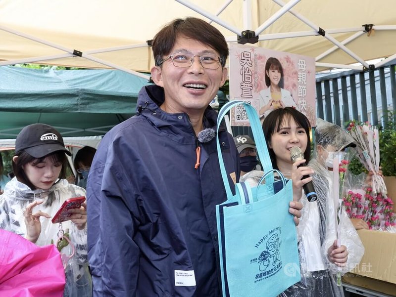 民眾黨主席黃國昌(前中)、發言人吳怡萱(前右)11日上午到台北市萬華雙和市場發康乃馨,祝福民眾母親節快樂。中央社記者張皓安攝 114年5月11日