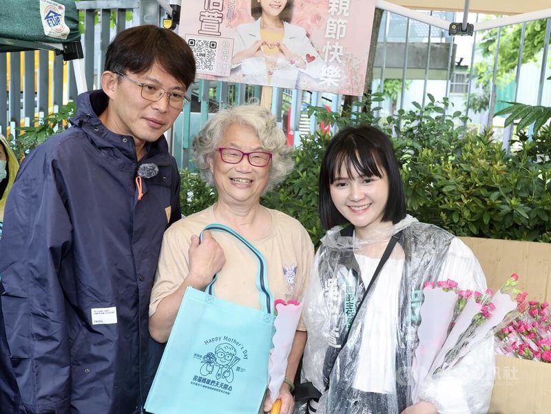 民眾黨主席黃國昌(左)、發言人吳怡萱(右)11日母親節到台北市萬華雙和市場發康乃馨,與民眾合影。中央社記者張皓安攝 114年5月11日