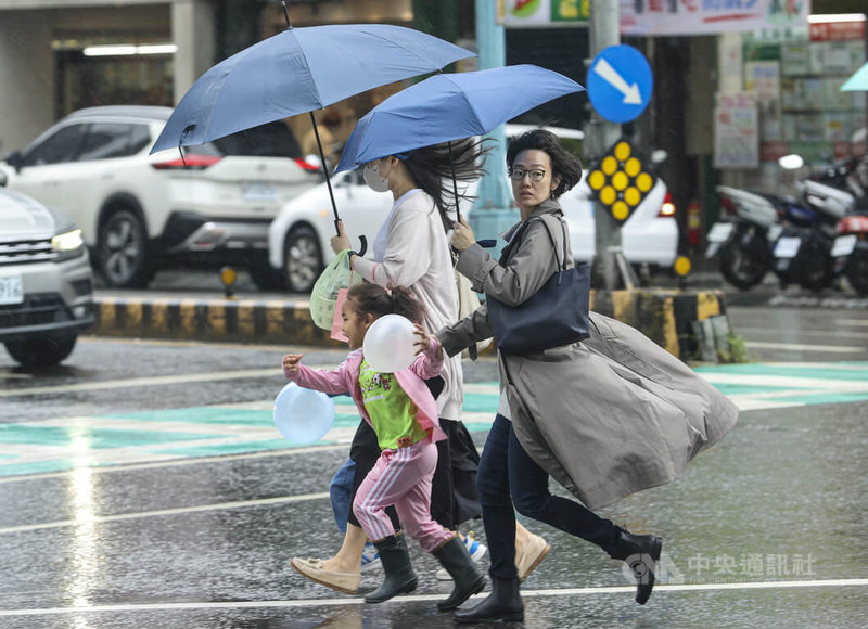 中央氣象署11日發布豪雨特報,受鋒面影響,易有短延時強降雨,大台北、基隆、中南部地區及苗栗山區有局部大雨發生機率。圖為新北市民眾撐傘快步過馬路。中央社記者鄭清元攝 114年5月11日