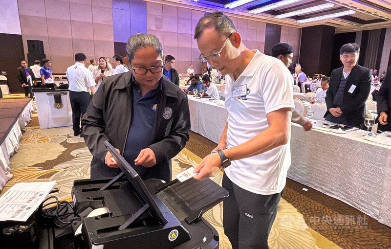 菲律賓將於12日舉行期中選舉,台灣民主基金會副執行長陳牧民前來馬尼拉觀選。圖為陳牧民(前右)在菲律賓選委會簡報會上試用菲國投票機。中央社記者林行健馬尼拉攝 114年5月11日