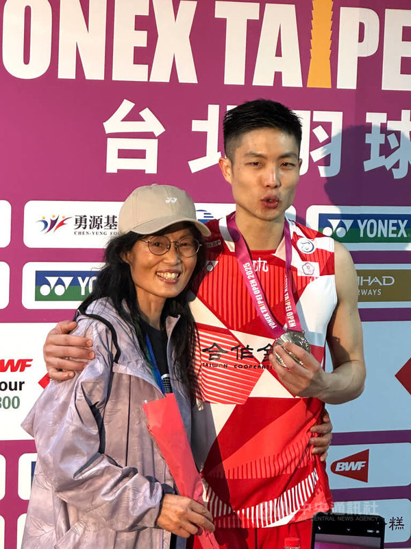 「台灣一哥」周天成(右)11日在台北羽球公開賽男單決賽落敗,雖無緣賽史生涯第5冠,但仍趁著母親節當天獻上康乃馨和銀牌給媽媽劉翠蓮(左),感謝她一路支持。中央社記者黎建忠攝 114年5月11日