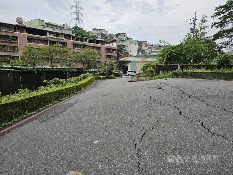 新北市汐止區伯爵街14巷巷口12日上午路面出現裂痕並傾斜,警方獲報趕抵現場設置封鎖線、雙向管制,並交通疏導。(翻攝照片)中央社記者趙敏雅傳真 114年5月12日
