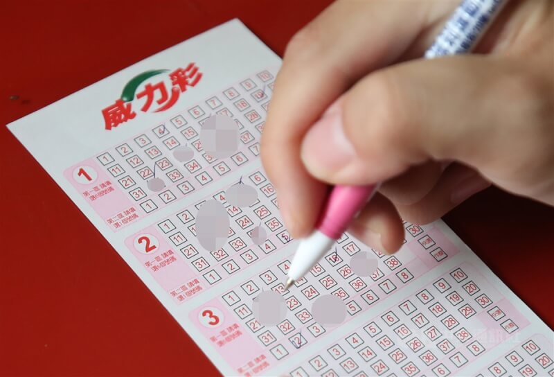 圖為購買威力彩民眾畫卡選號。(中央社檔案照片)