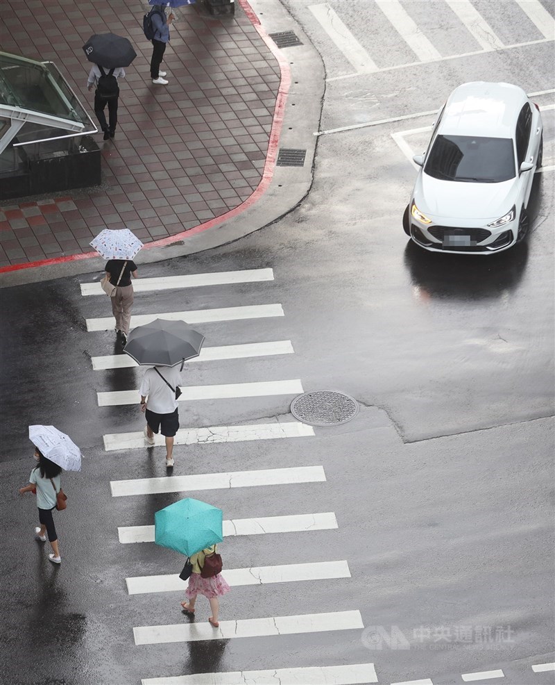 圖為汽車路口轉彎時停等行人通過。(中央社檔案照片)
