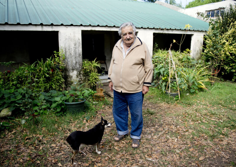 2014年穆西卡在自住的農場小屋與愛犬合影。(美聯社)