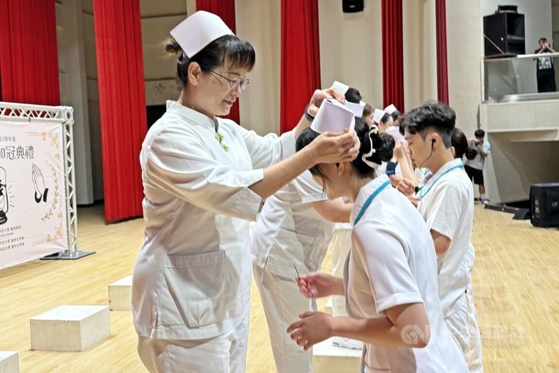 弘光科技大學護理學院為225名護理科、護理系與學士後護理系學生舉辦加冠典禮，彰濱秀傳醫院護理部主任吳美娟（左）親自為女兒黃秋瑜（右）加冠。中央社記者趙麗妍攝  114年5月16日
